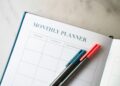 a planner with two pens sitting on top of it