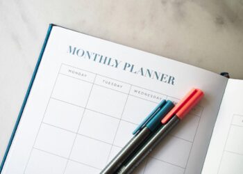 a planner with two pens sitting on top of it
