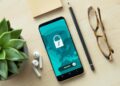 A smartphone displaying a security lock icon on a wooden desk with a succulent