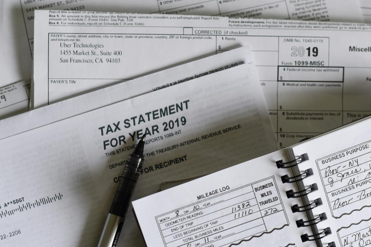 A pen resting on 2019 tax forms and a mileage log book